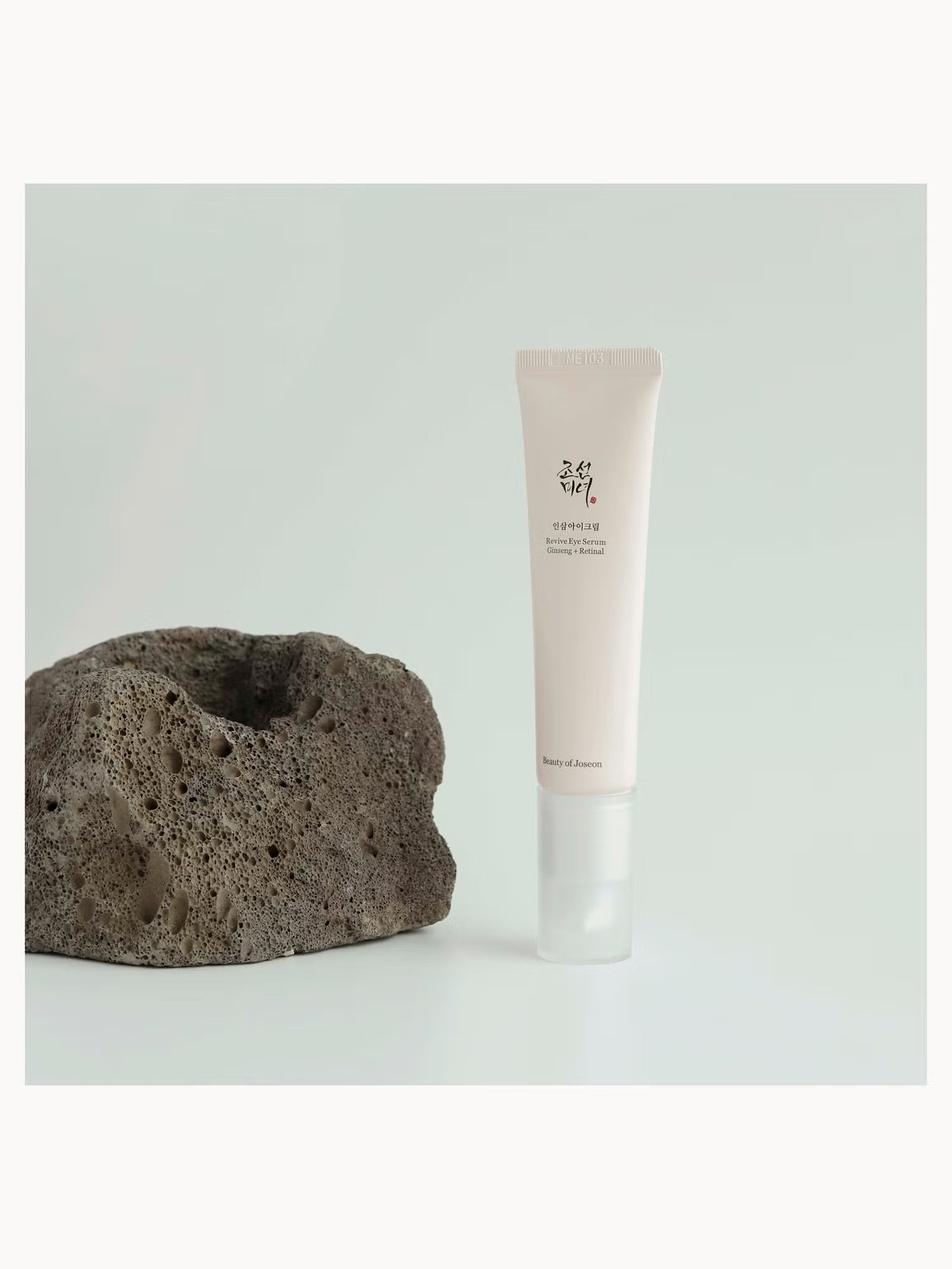 Skincare tube and volcanic stone on a light grey background. Beauty of joseon eye serum at give us beauty