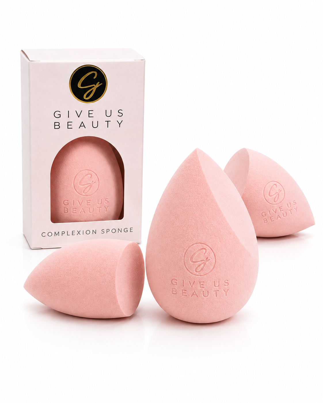 Three pink teardrop-shaped makeup sponges with embossed 'GIVE US BEAUTY' logos, displayed alongside their white retail box on a clean white background.